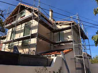 Maison entourée d’un échafaudage complet pendant la réfection de sa toiture