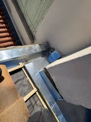 Noue en zinc neuve posée contre un mur, sur écran sous-toiture et liteaux